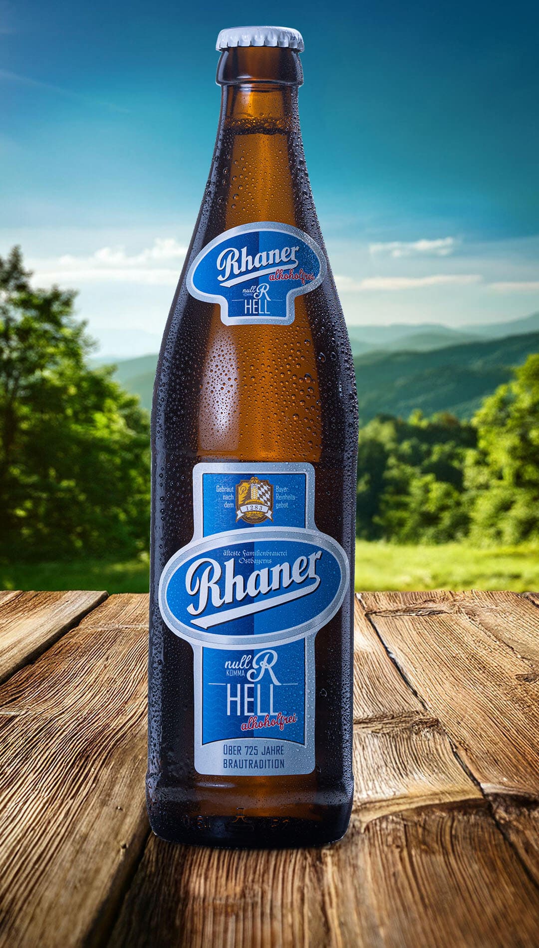 Eine Flasche Rhaner "Null Komma R" Hell alkoholfrei mit blau-silbernem Etikett auf einem Holztisch vor einer grünen Hügellandschaft