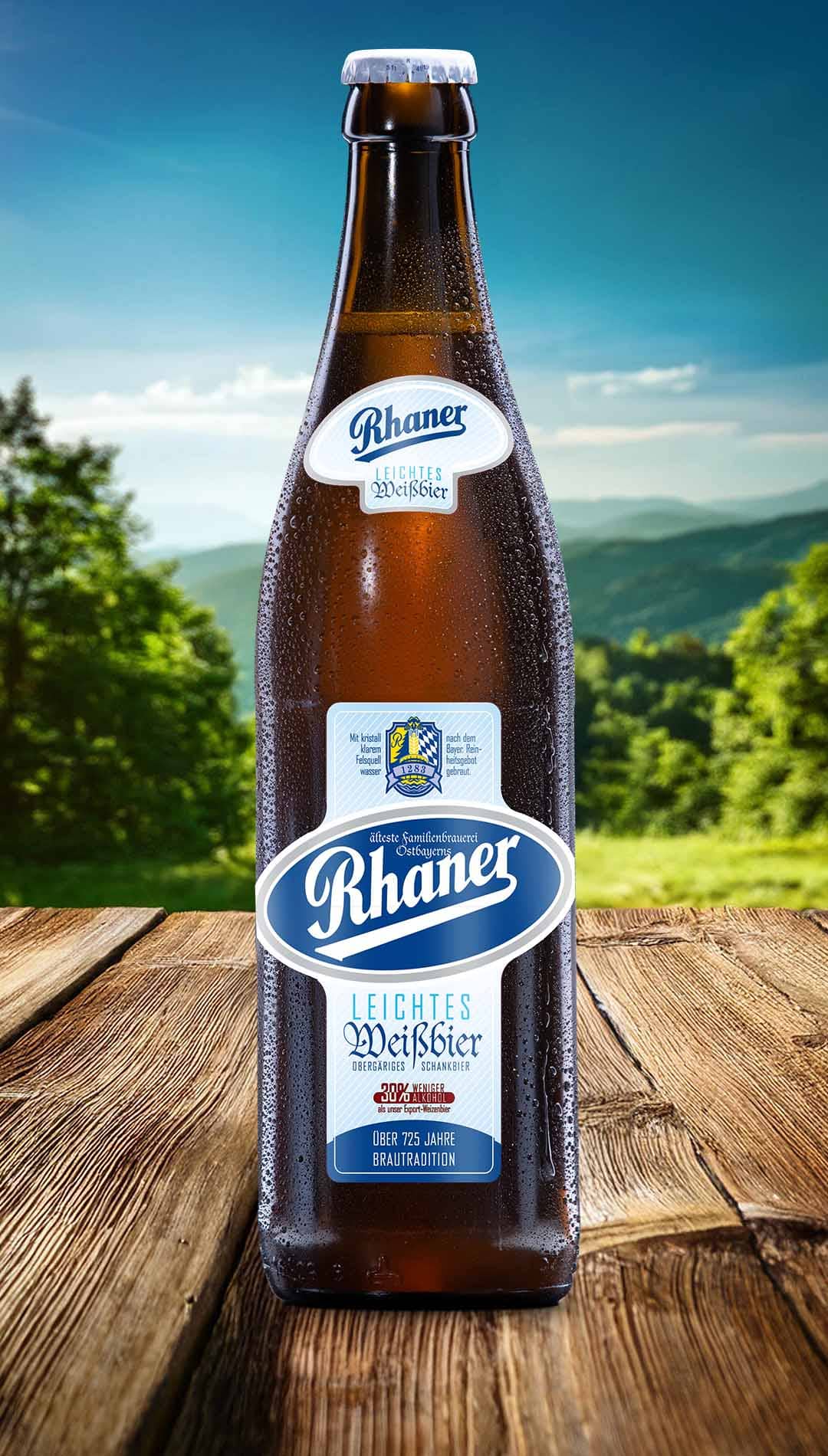 Eine Flasche Rhaner Leichtes Weißbier mit hellblau-weißem Etikett auf einem Holztisch vor einer grünen Hügellandschaft