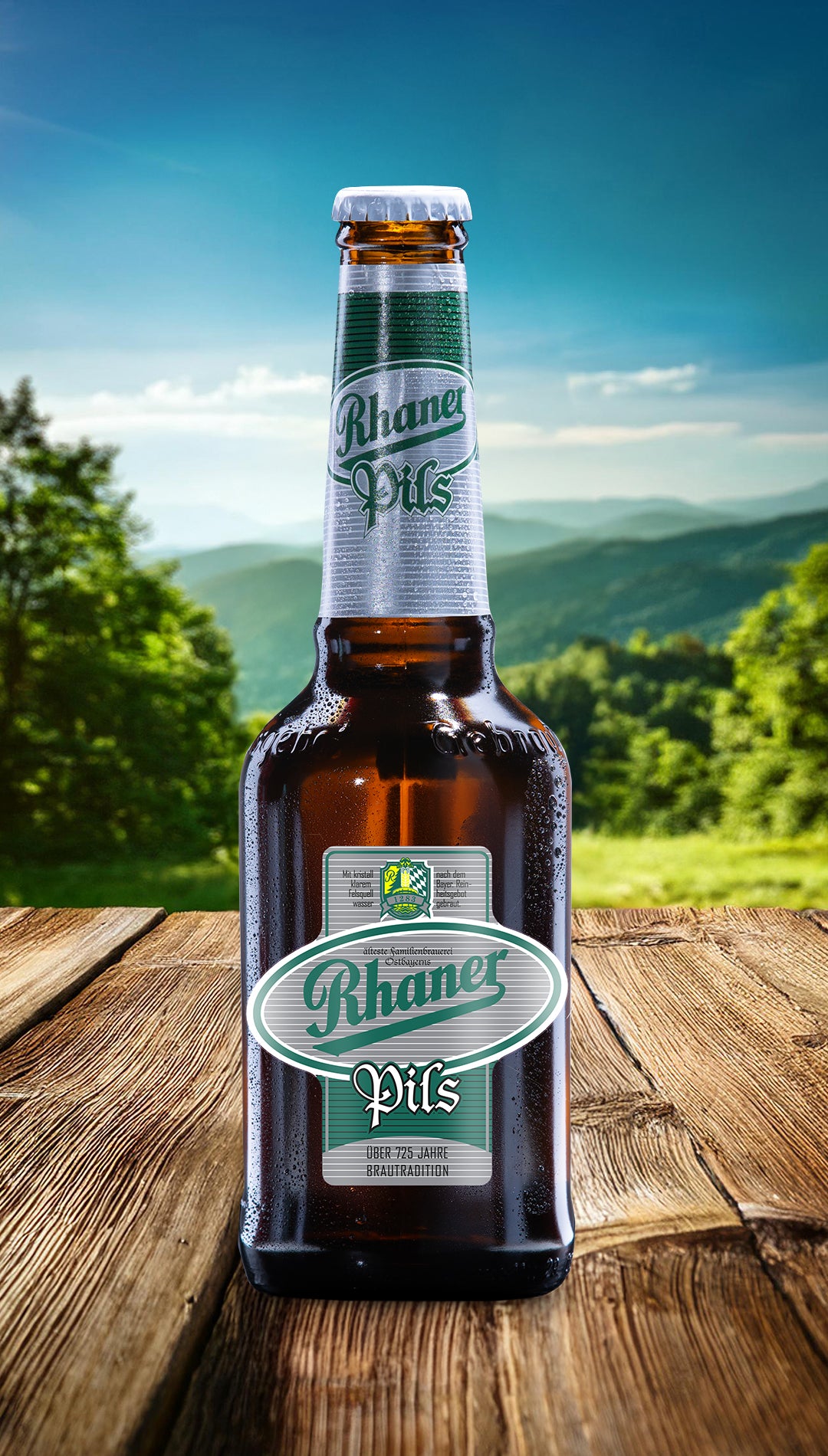 Eine Flasche Rhaner Pils mit grün-weißem Etikett auf einem Holztisch vor einer grünen Landschaft