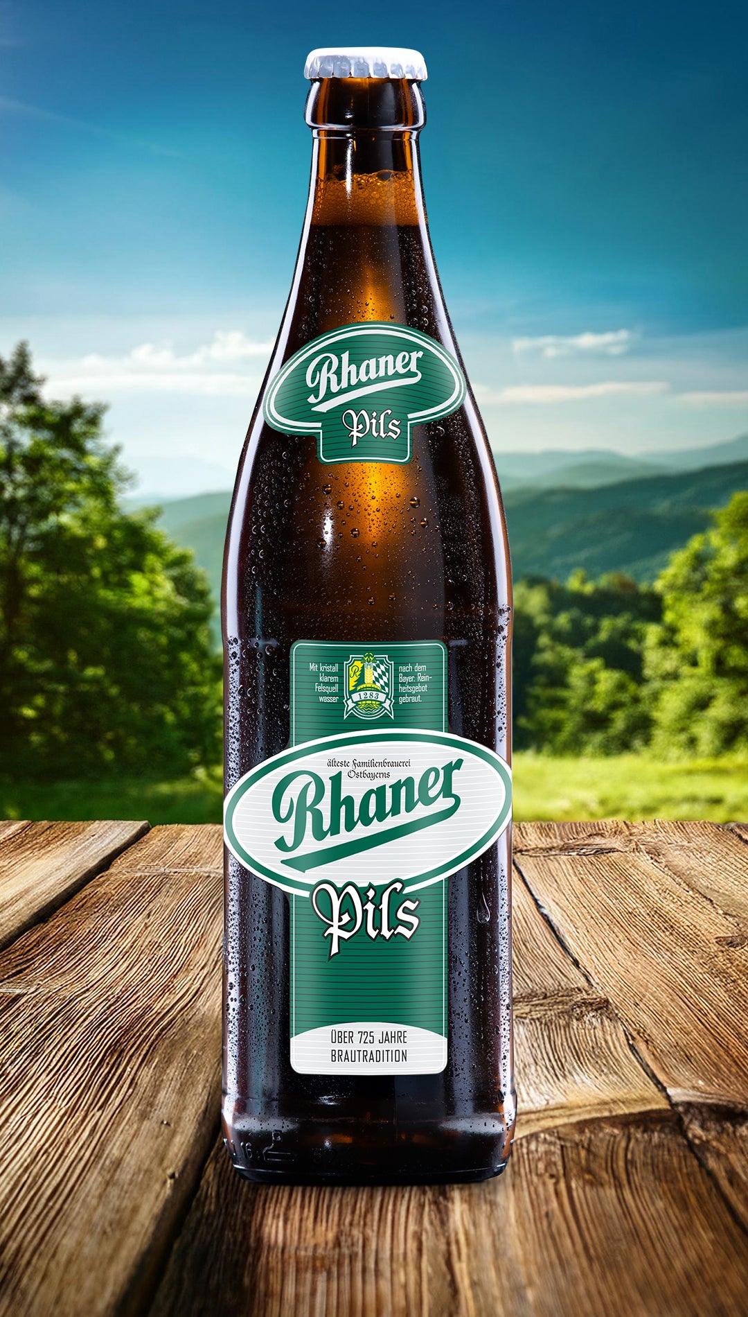 Eine Flasche Rhaner Pils mit grün-weißem Etikett auf einem Holztisch vor einer grünen Landschaft